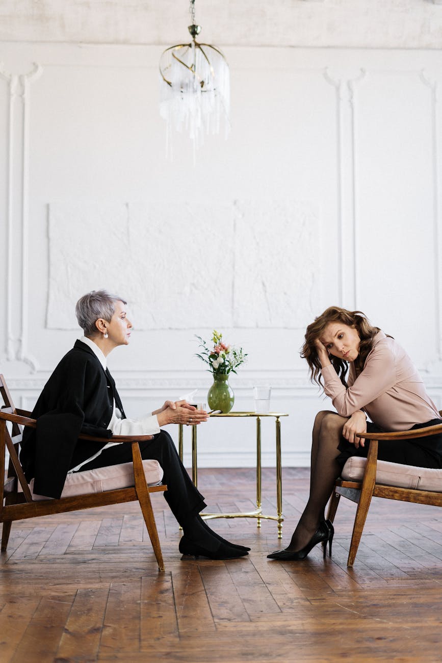 man and woman sitting on brown wooden chair