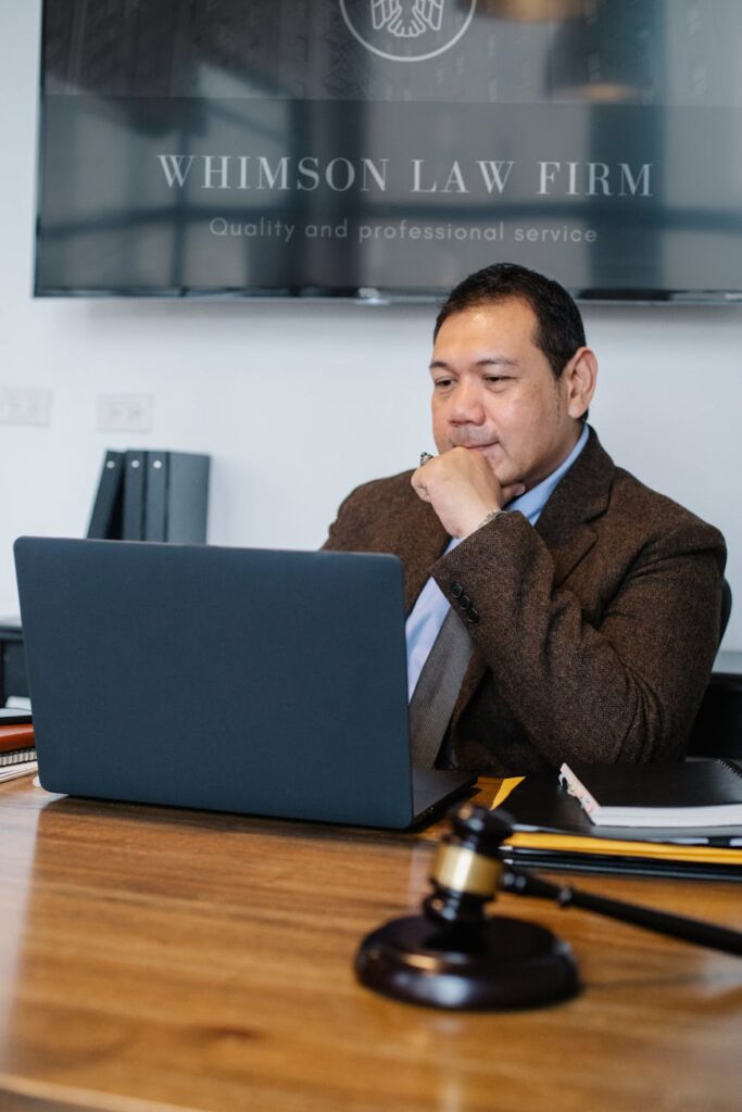 thoughtful asian lawyer browsing laptop in law office