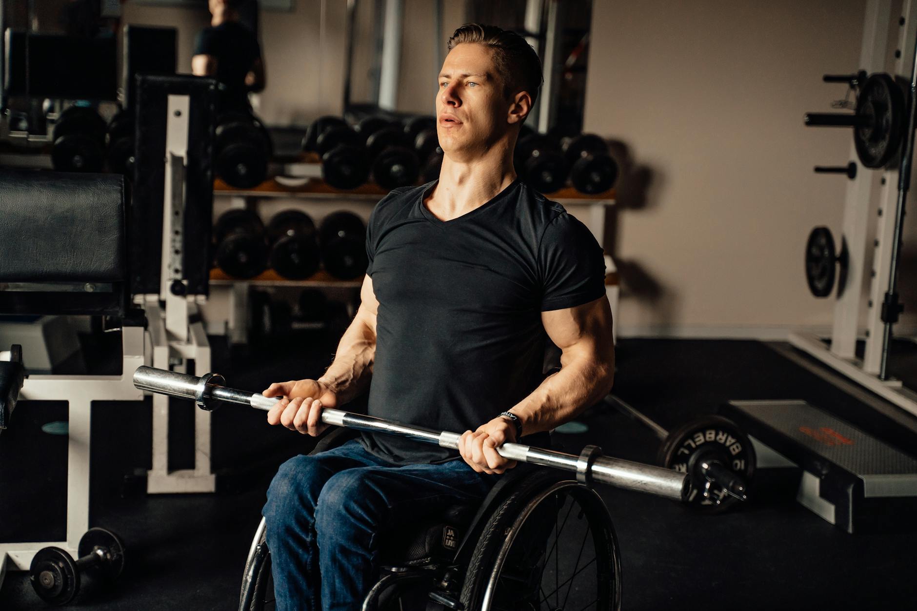 man in black crew neck t shirt holding gray barbell