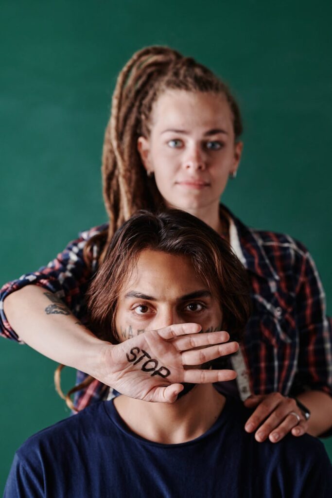 woman holding hand in front of man face