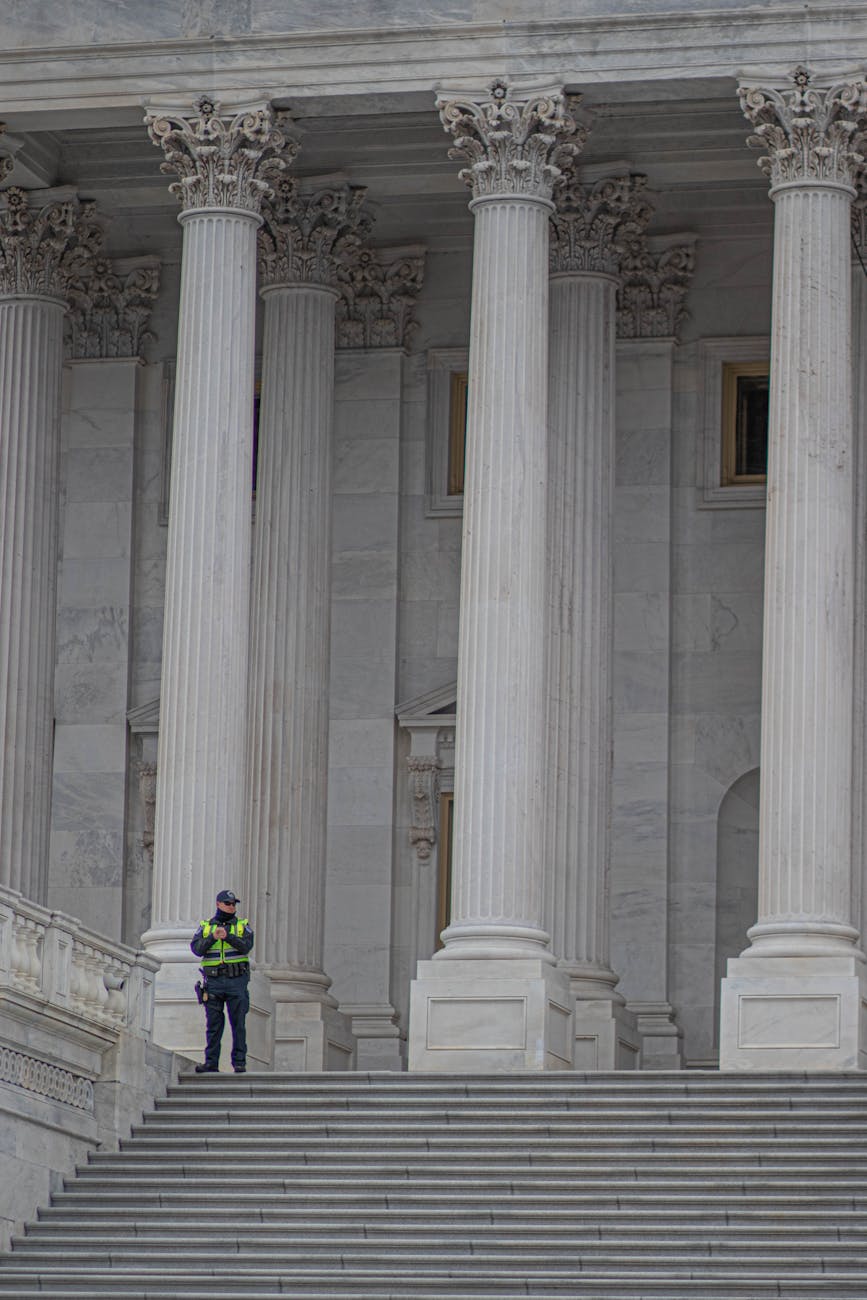 a police officer standing near white concrete pillars of a building
