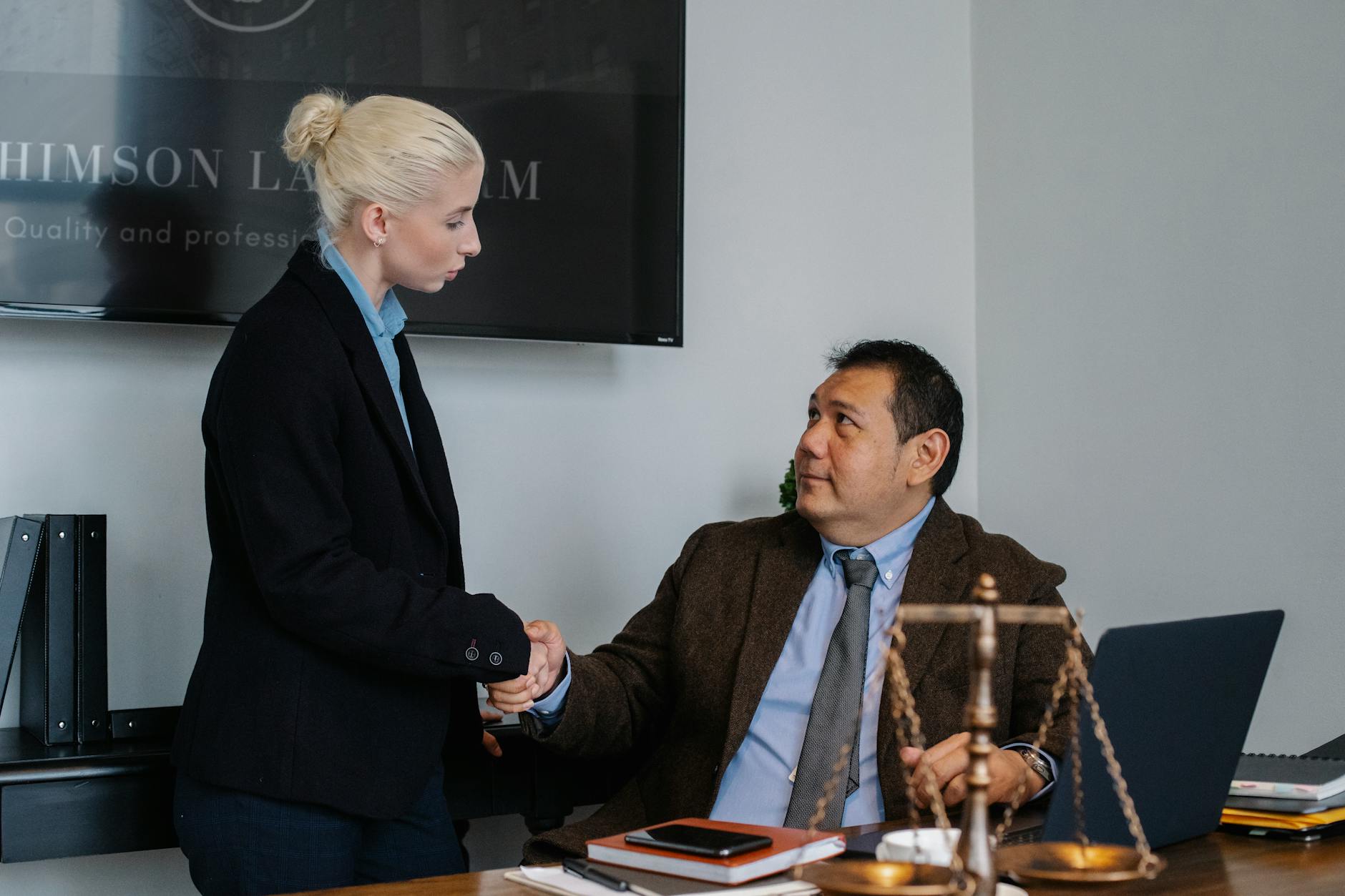 diverse colleagues of juristic agency shaking hands together in office