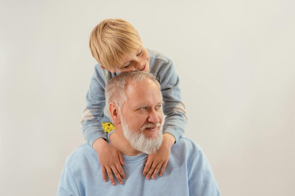 a young boy embracing his grandfather