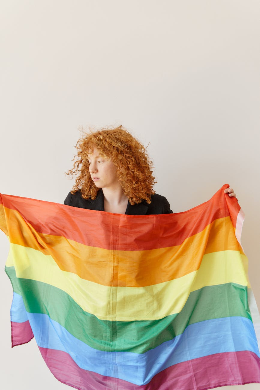 woman in black shirt holding green yellow and red striped flag