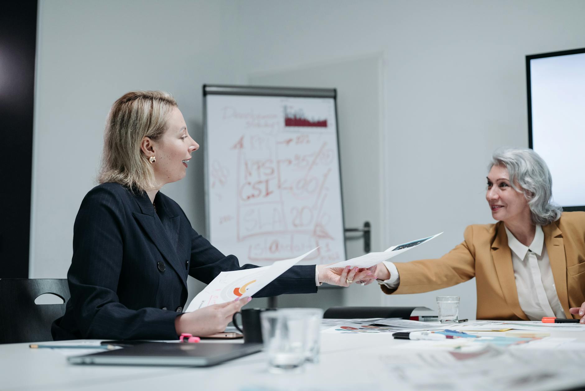 woman passing a document to her colleague