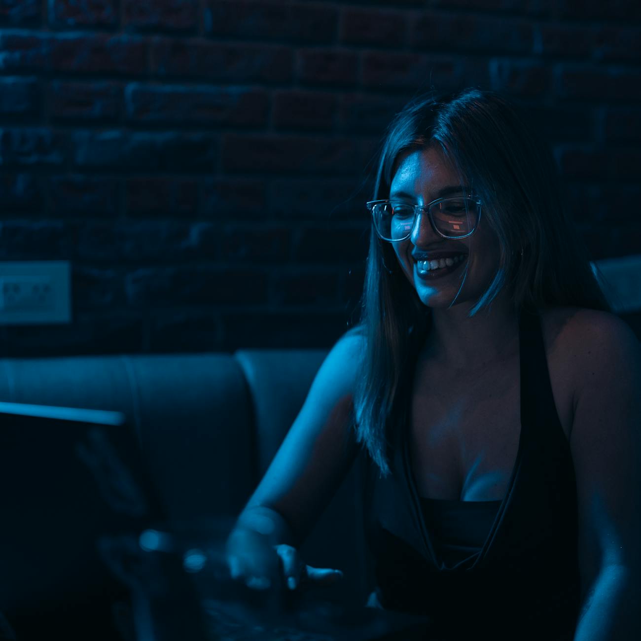 smiling woman working on laptop in cozy evening ambiance