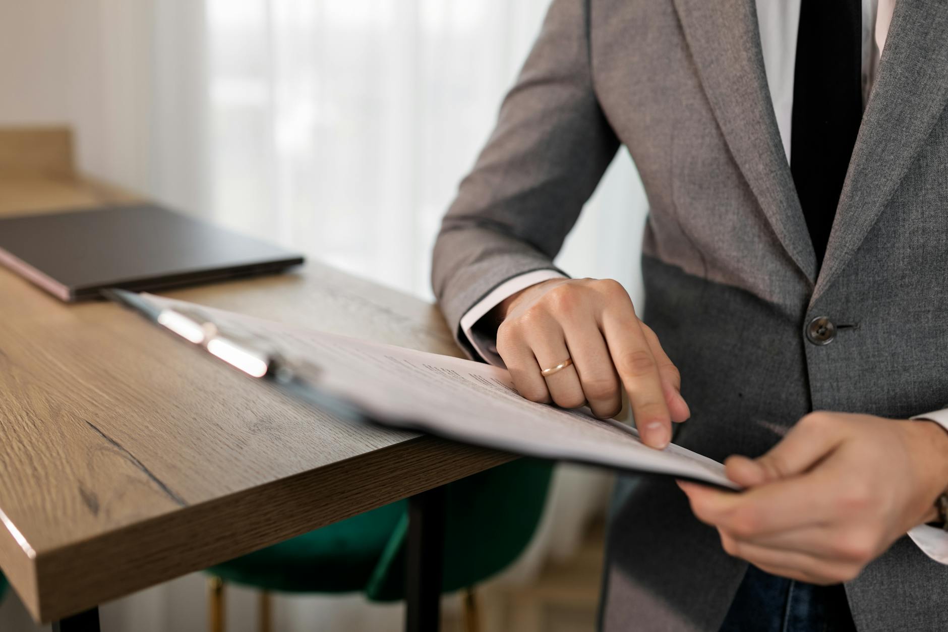 a person in gray suit holding black clipboard